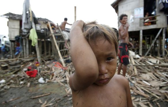 Typhoon victims stand outside their homes damaged by Typhoon Rammasun (locally named Glenda) in a village of sea gypsies, also known as Badjaos, in Batangas city, south of Manila, July 17, 2014. REUTERS/Erik De Castro