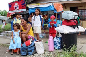 Tacloban residents wait for a government vehicle to bring them to the evacuation center in Tacloban City on Thursday in anticipation of typhoon Ruby's impact. Ruby, packing winds of up to 195 kph with gusts of up to 230 kph, was expected to make landfall on Saturday. (ABS-CBN News)